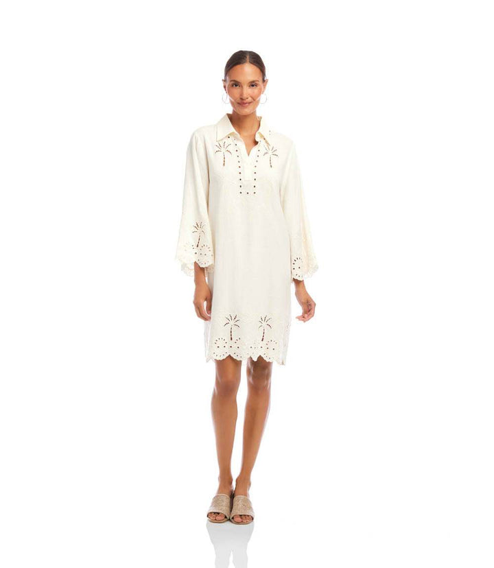 Woman wearing white flare sleeve embroidered shirtdress with cutout details and button-down front