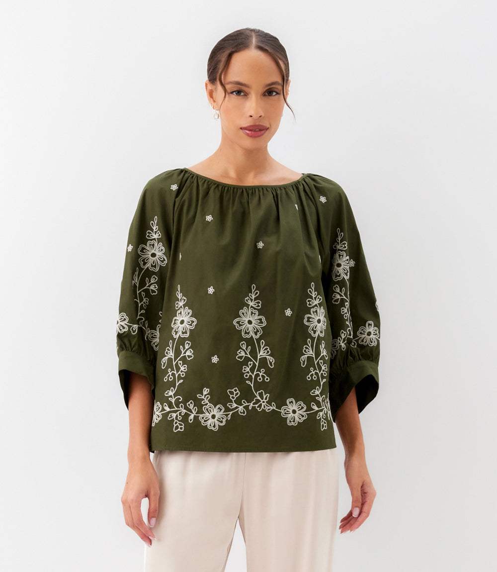 Woman wearing embroidered blouson sleeve top with cream embroidery and voluminous sleeves