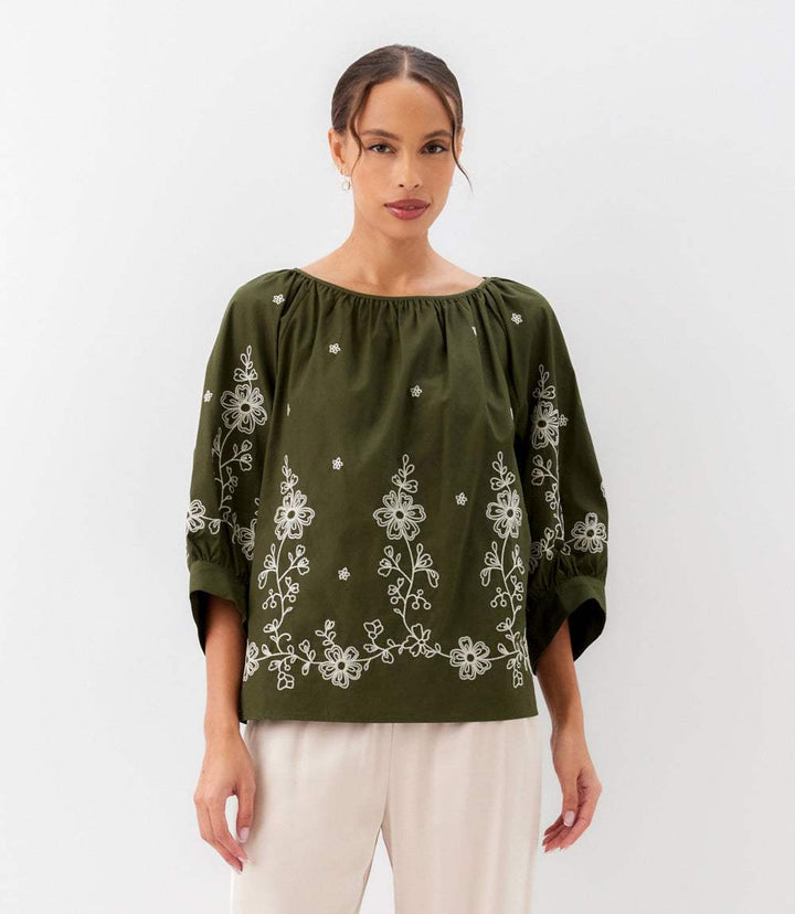 Woman wearing embroidered blouson sleeve top with cream embroidery and voluminous sleeves