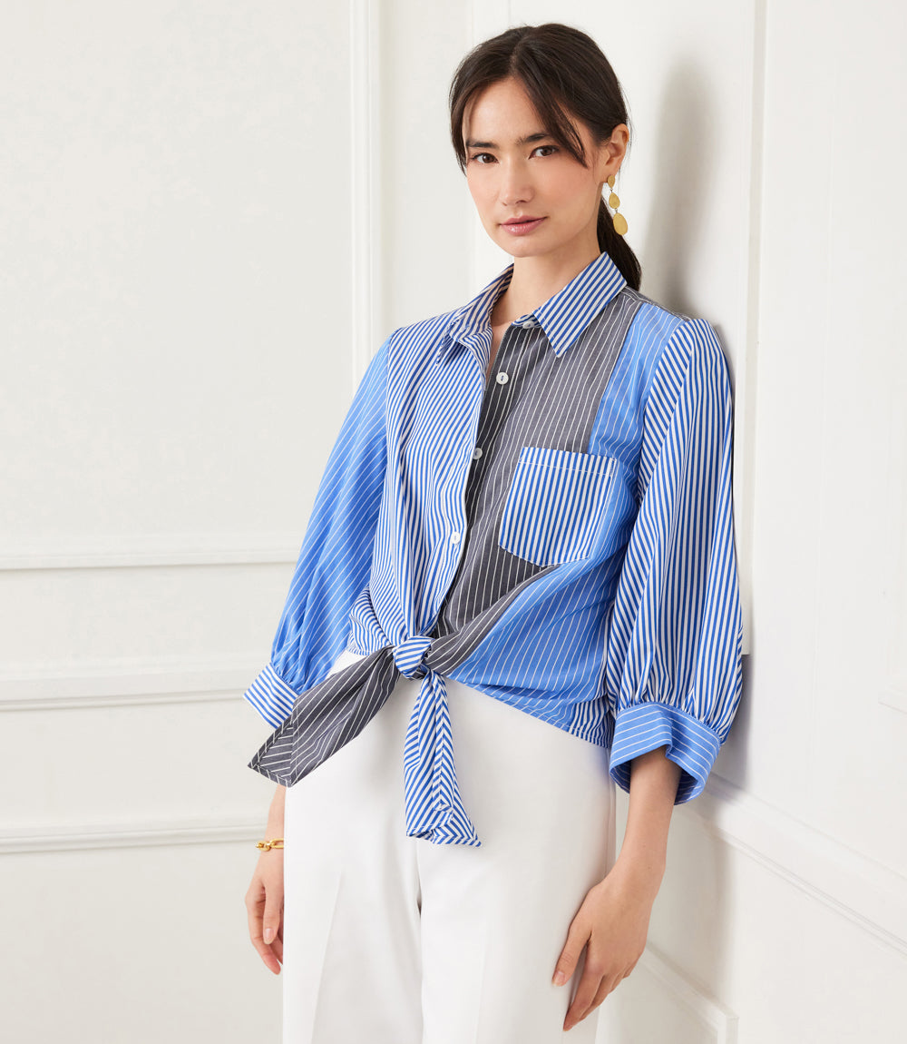 Woman wearing blouson sleeve mixed blue and gray striped tie-front collared top with front pocket and button closure