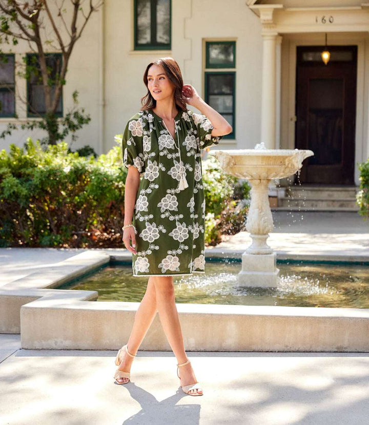 Woman wearing a breathable cotton puff sleeve tassel dress with tie neck and side pockets