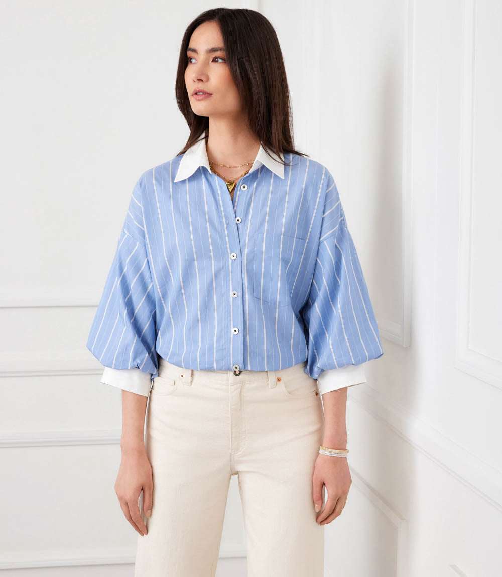 Woman wearing a stripe lantern sleeve button-up shirt with thick and thin stripes, voluminous sleeves, and a crisp collar