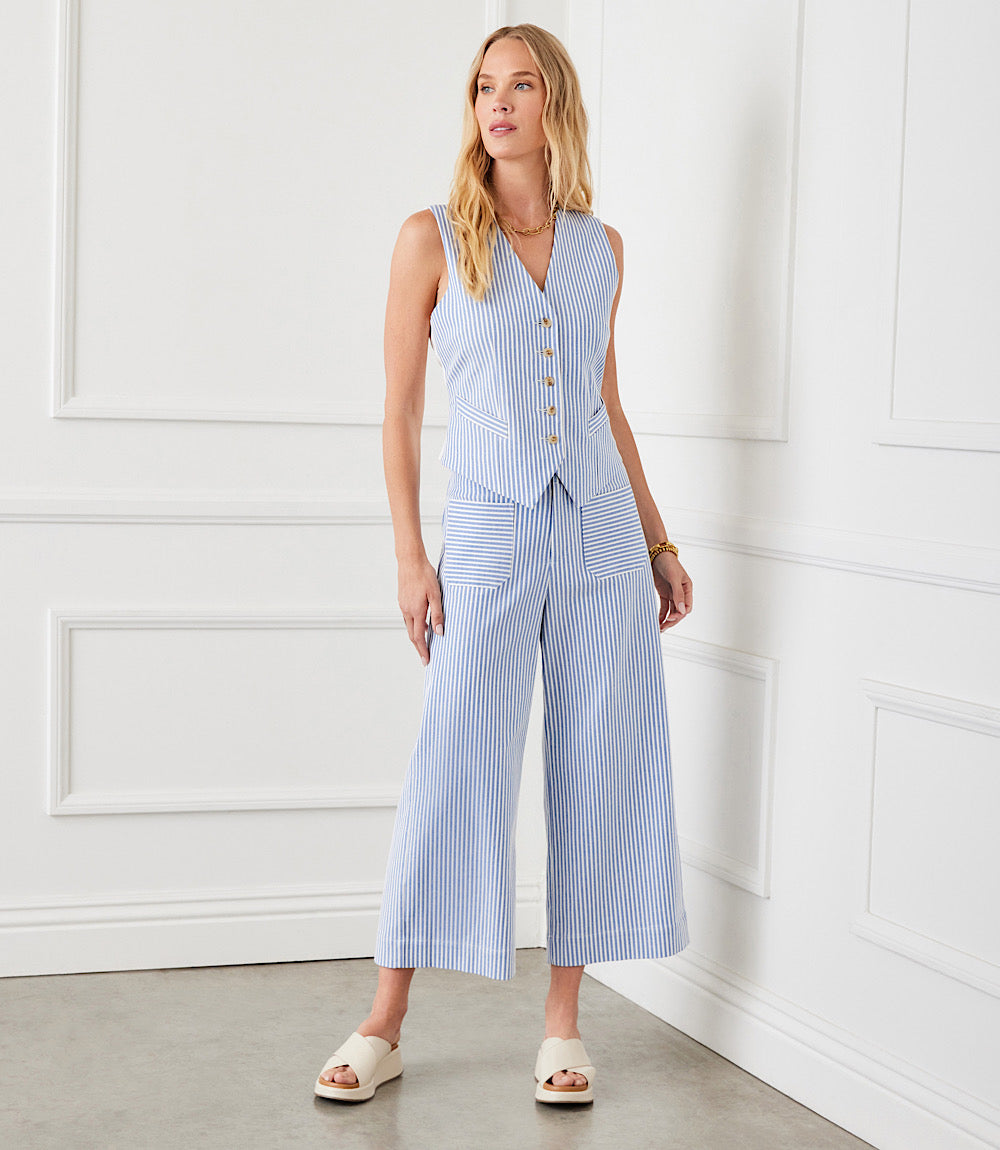 Woman wearing blue and white striped close-fitting Stripe Button-Up Vest with tortoise shell buttons and back ties