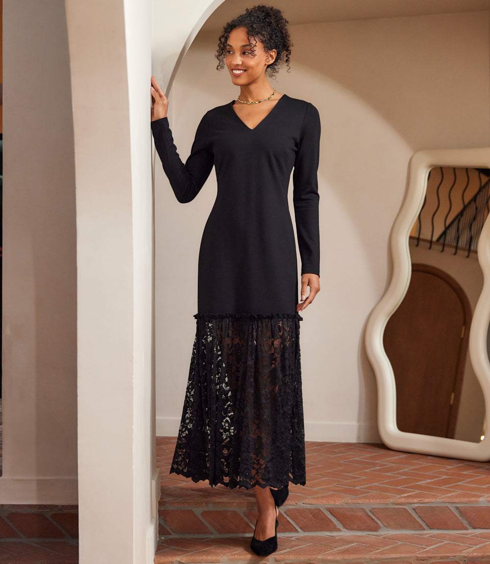 woman wearing a black long sleeve contrast lace V-neck column dress with lace skirt and ruffle trim