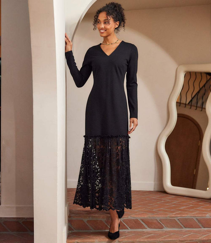 woman wearing a black long sleeve contrast lace V-neck column dress with lace skirt and ruffle trim
