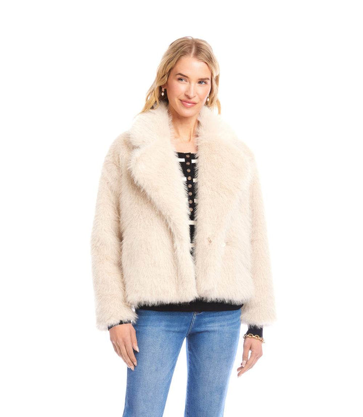 Woman wearing a cream cropped faux fur jacket with wide collar and button front closure paired with jeans