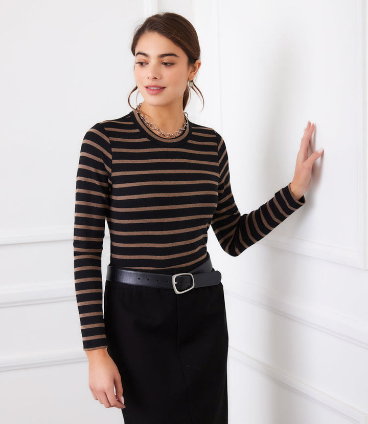 Woman wearing a black and brown horizontal stripe long sleeve crewneck top with black pants and a belt.