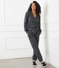 Woman wearing gray leopard print animal print sweatpants with drawstring waist and elasticized ankles, styled with matching top and black sneakers