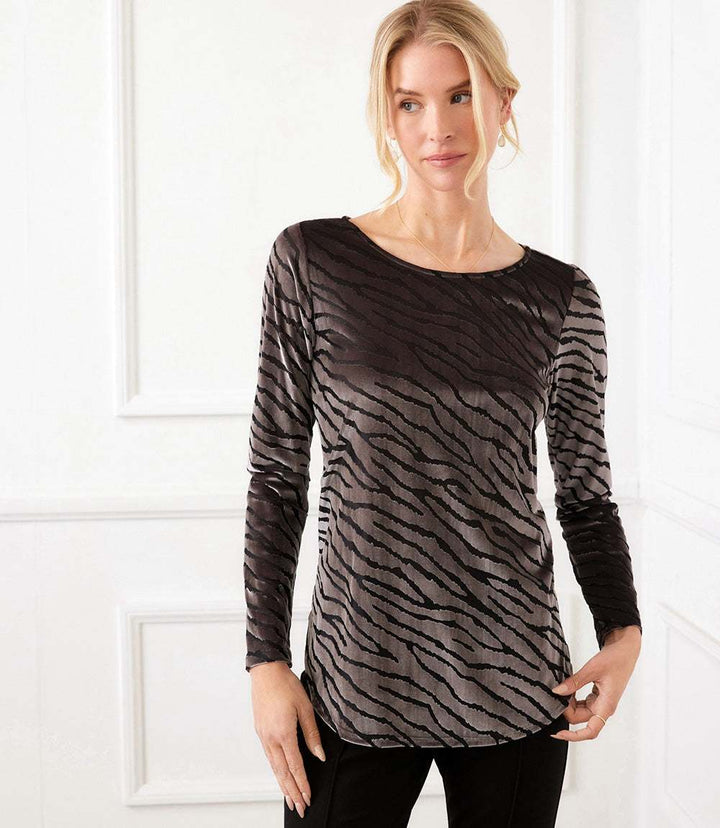 Woman wearing silver and black long sleeve velvet burnout top with zebra pattern and scoop neckline