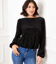 Woman wearing black blouson sleeve velvet burnout boatneck top with elastic cuffs and leopard print detail