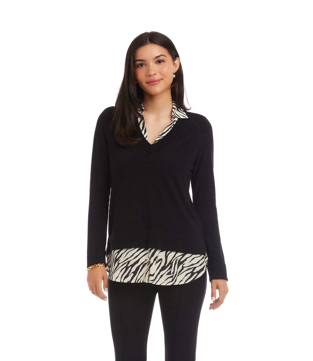 Woman wearing layered contrast zebra sweater with black sleeves and zebra print hem and collar