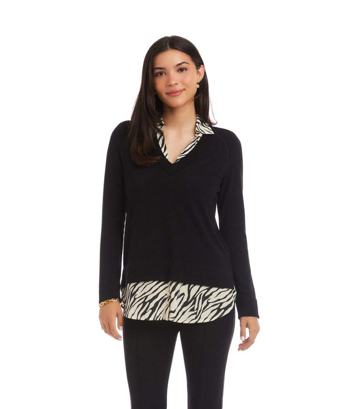 Woman wearing layered contrast zebra sweater with black sleeves and zebra print hem and collar