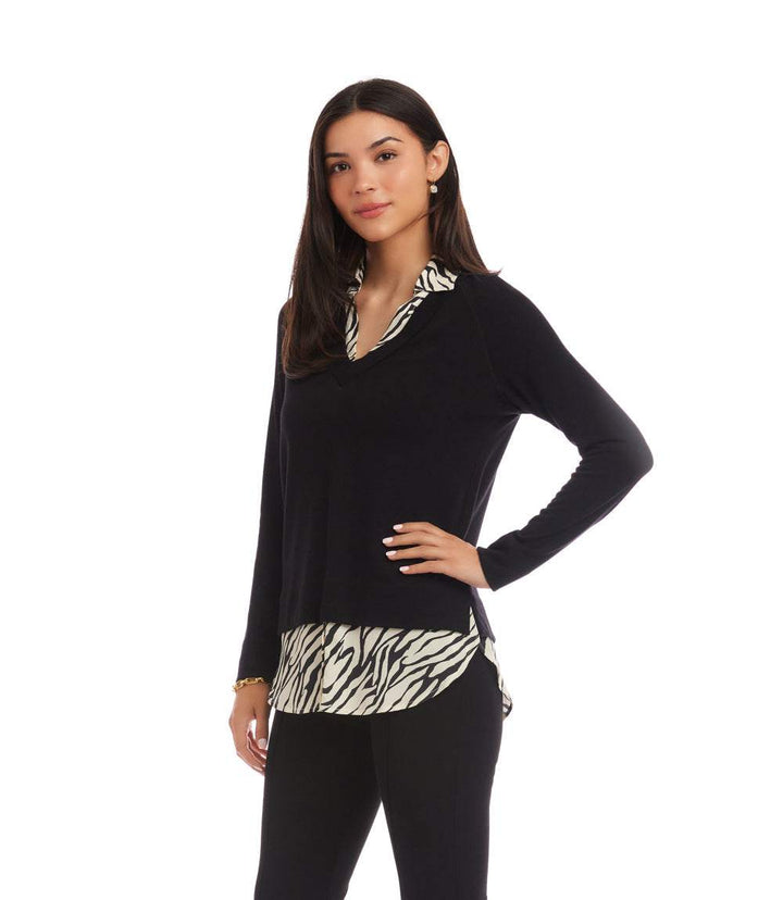 Woman wearing a layered contrast zebra sweater with black sleeves and zebra print collar and hem.