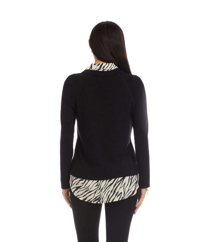 Back view of a woman wearing a layered contrast zebra sweater with solid black sleeves and zebra print collar and hem