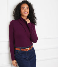 Woman wearing a slim fit ribbed faux wrap turtleneck top in deep purple