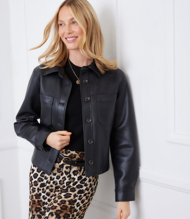 woman wearing black faux leather cropped jacket with button closures and leopard print skirt