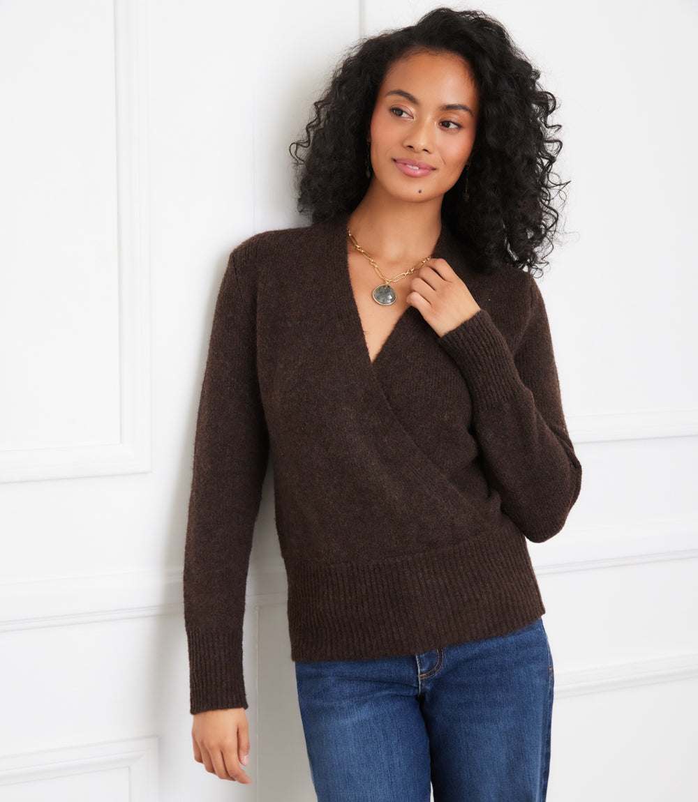 Woman wearing a brown wrap sweater with crossover V-neck and drop shoulder sleeves