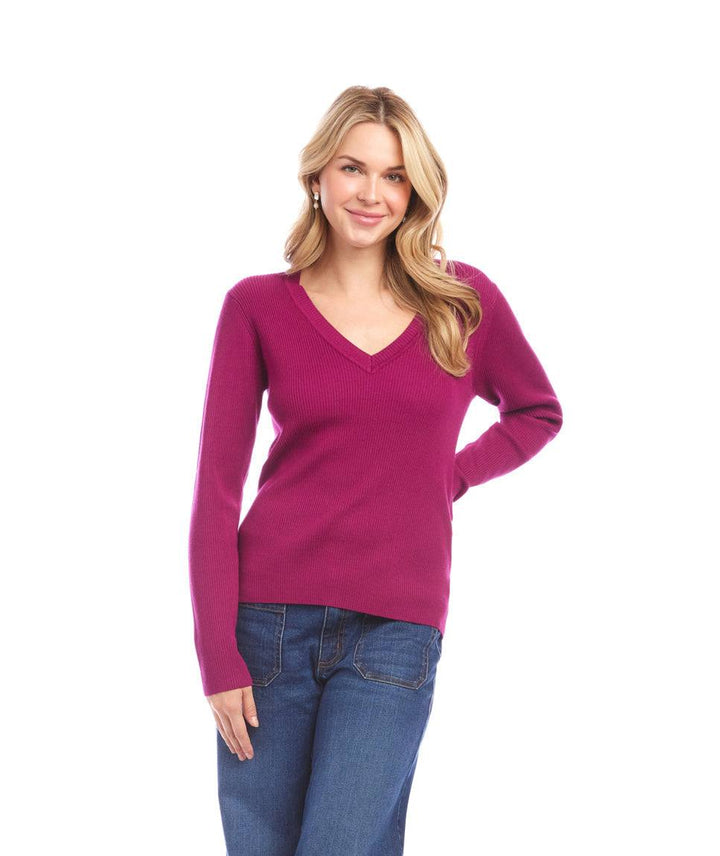 Woman wearing fitted ribbed V-neck sweater in magenta with long sleeves and slim silhouette