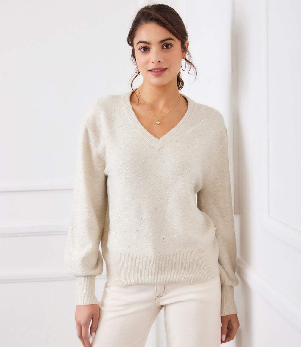 Woman wearing a cream Sequin V-Neck Sweater with long sleeves and ribbed cuffs and hem