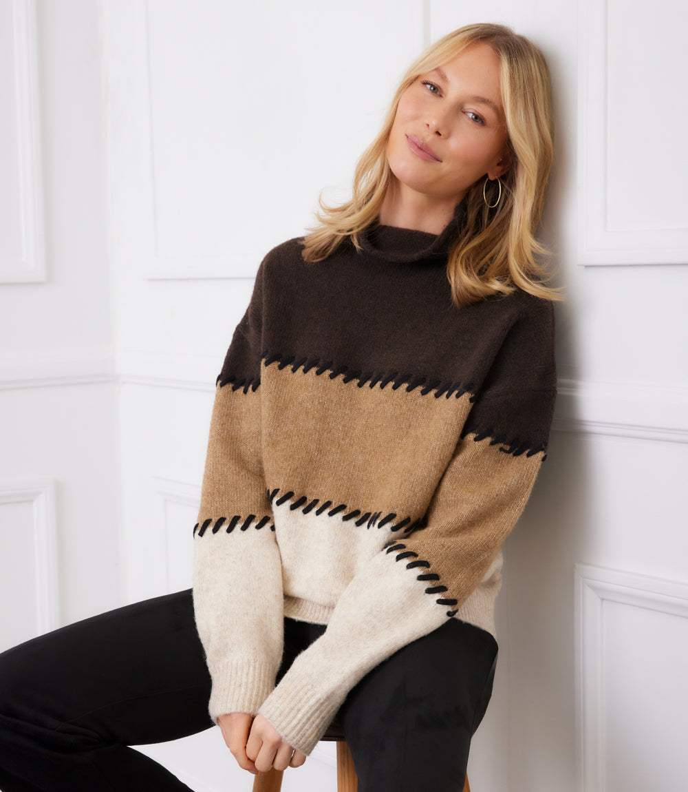 Woman wearing petite size colorblock sweater with contrast stitch mock neck and drop shoulder sleeves