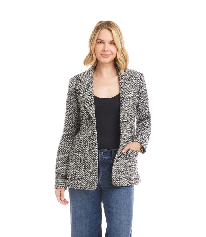 Petite size tweed blazer with collar, front pockets, and snap closures in black and white textured fabric.
