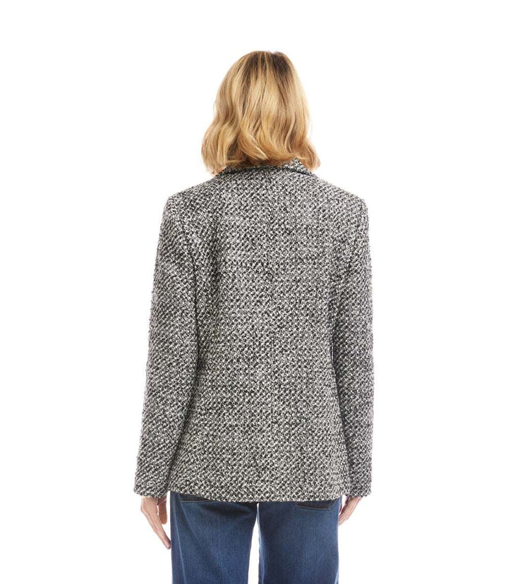 Back view of a petite size tweed blazer with a textured woven fabric and collared neckline worn by a model
