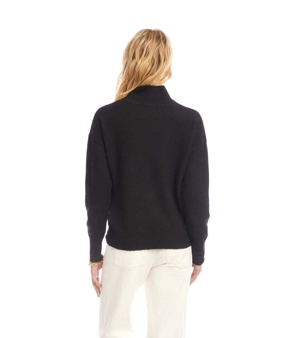Woman wearing black shawl collar sweater with relaxed fit and drop shoulder sleeves, viewed from the back
