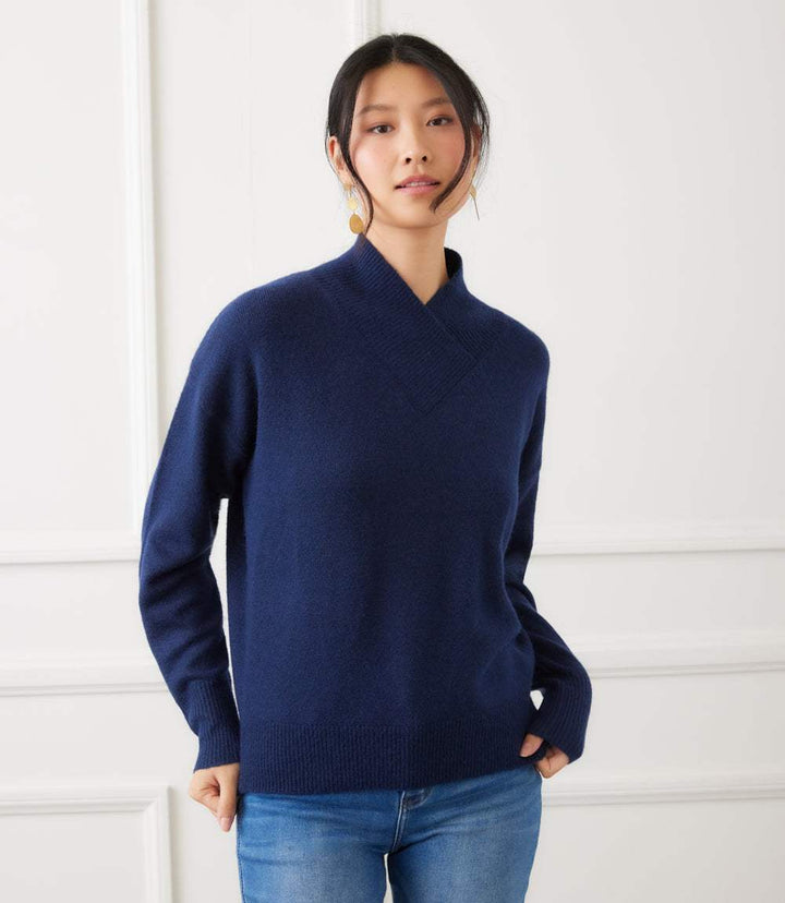 Woman wearing navy blue shawl collar sweater with drop shoulder sleeves and ribbed cuffs paired with jeans