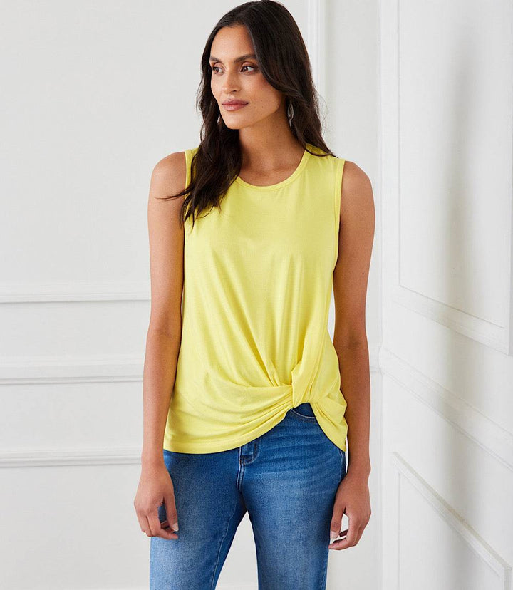 Woman wearing a yellow sleeveless pick-up top with side twist hem and crew neck paired with blue jeans