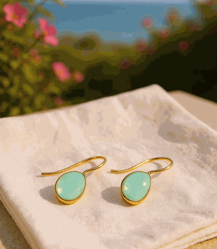 Gemstone teardrop earrings with aqua chalcedony and 18ct gold plating on white cloth