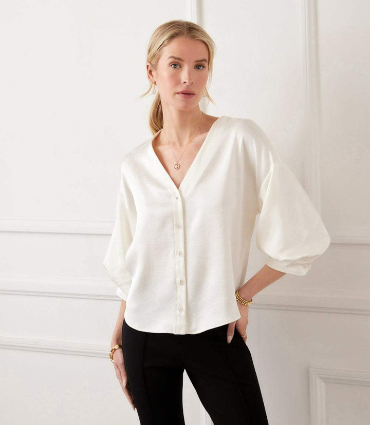 White satin blouse with lantern sleeves and crystal rhinestone buttons on V-neckline