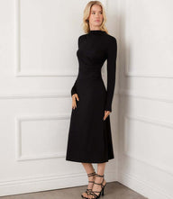 Woman wearing black Elise long sleeve side-shirred midi dress with mock neck and fitted bodice
