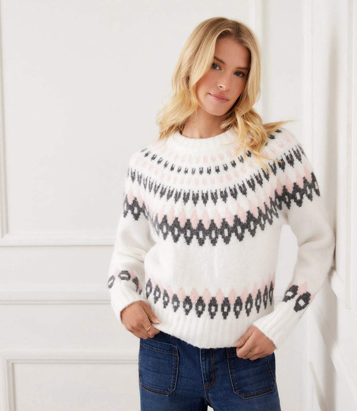 Woman wearing white jacquard crewneck sweater with pink and black geometric pattern and long raglan sleeves