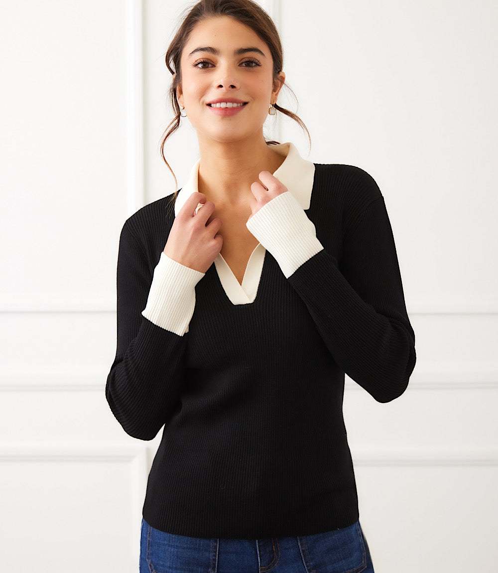 Woman wearing black contrast ribbed polo sweater with white collar and cuffs, V-neckline, and long sleeves.