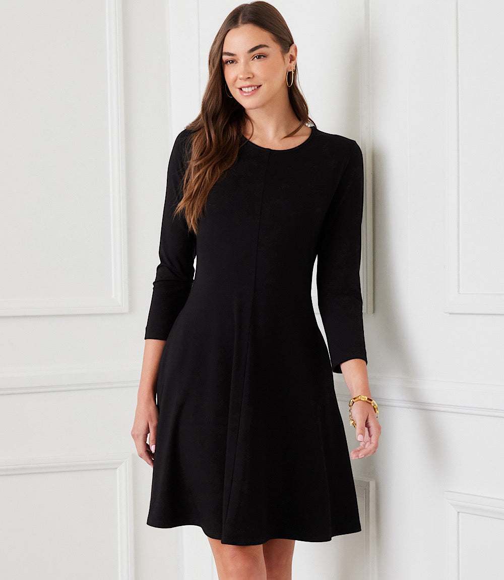 Woman wearing black 3/4 sleeve fit and flare dress with scoop neck and front seam detail