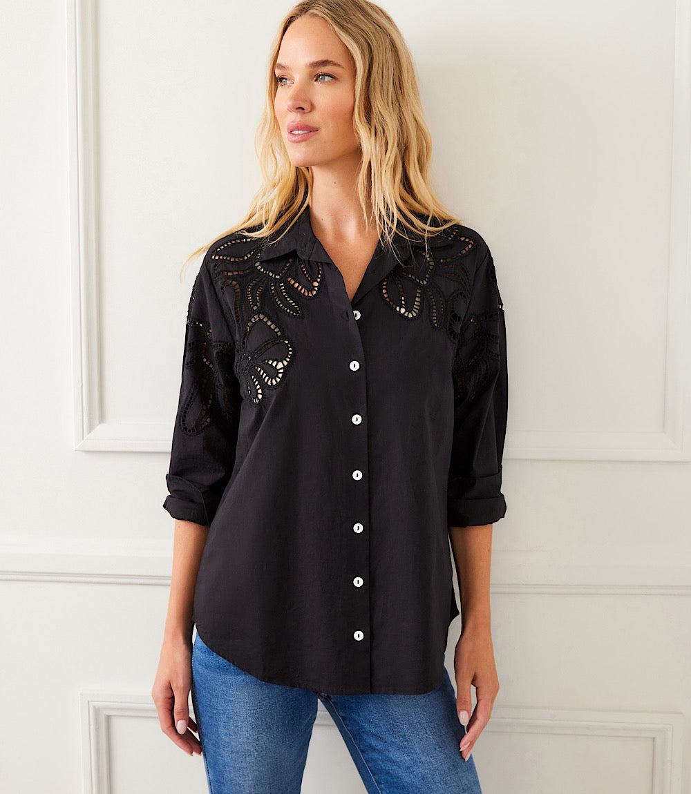 Woman wearing black long sleeve cutout embroidery shirt with button-up front and collar