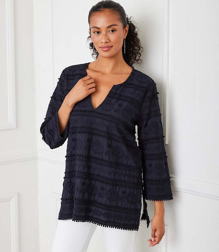 Woman wearing a black 3/4 sleeve embroidered cotton tunic with a split neck and flare sleeves.