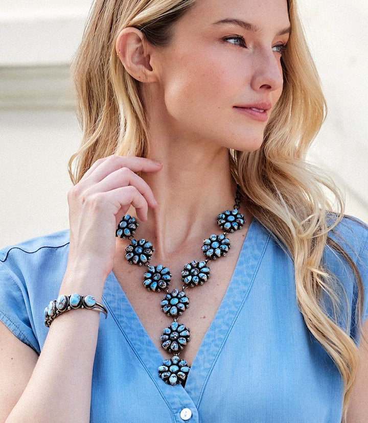 Woman wearing Golden Hill Turquoise cuff bracelet and matching turquoise necklace with sterling silver detailing