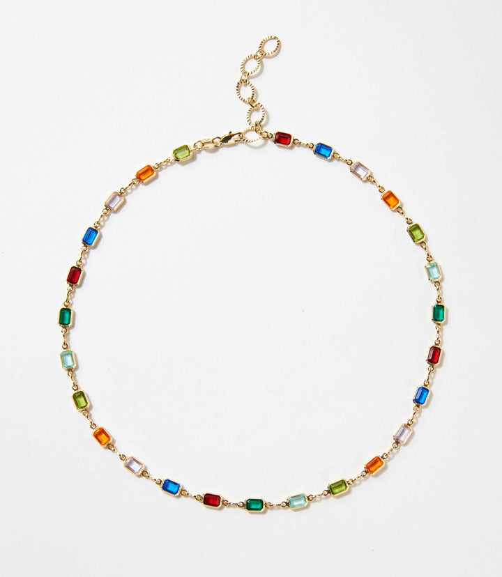 Colorful gemstone necklace with 18K gold chain featuring red, blue, green, and purple stones