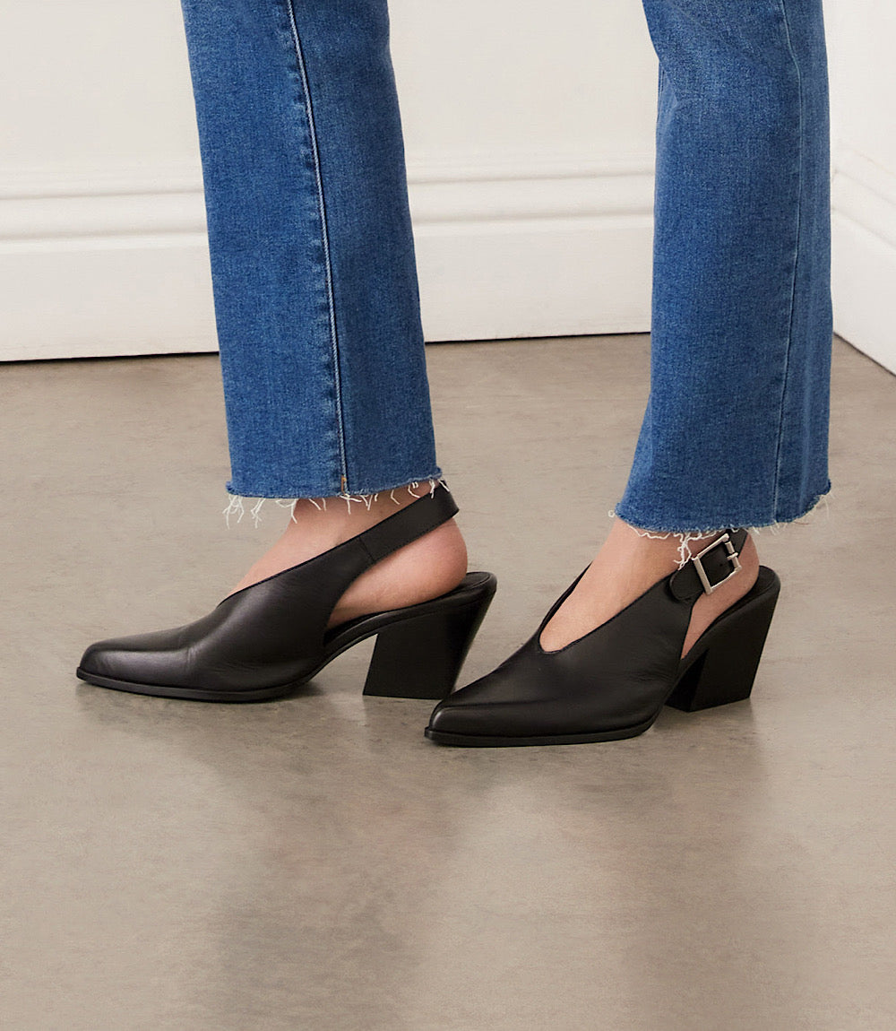 Seychelles Baby Faced Sling Back Heels in black leather with pointed toe, block heel, and adjustable buckle strap worn with blue jeans