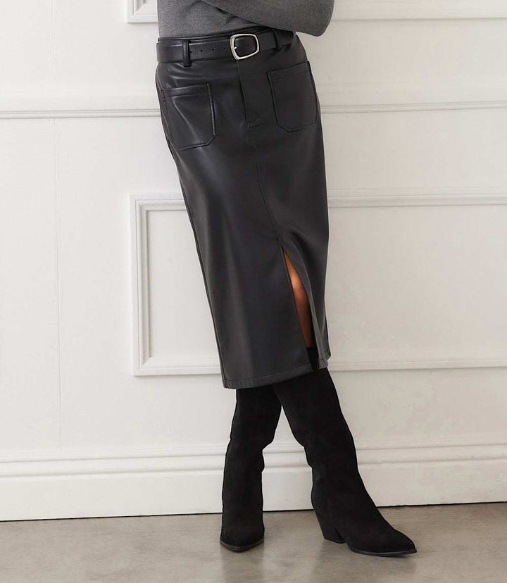 Black faux leather midi skirt with front slit, button and zip closure, belt loops, and four patch pockets, worn with black heeled boots.