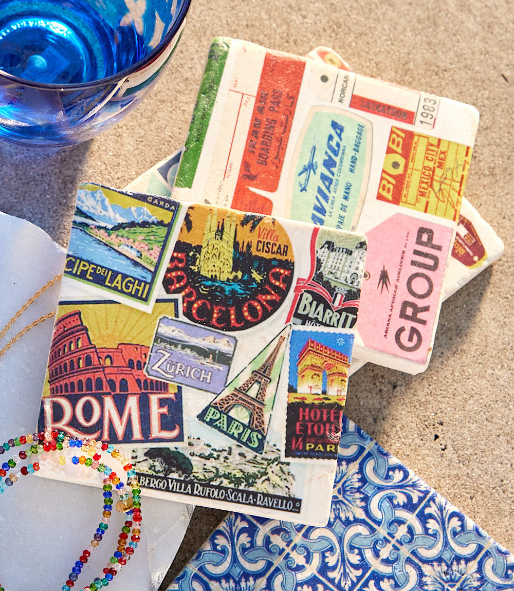 Set of four luggage tag marble coasters with vintage travel designs on tumbled marble and cork backing
