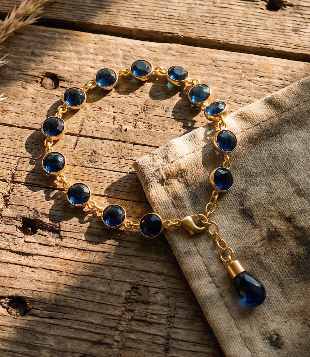 Sapphire crystal bracelet with blue sapphire crystals and gold-tone design on a white background