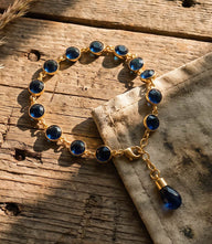Sapphire crystal bracelet with blue sapphire crystals and gold-tone design on a white background