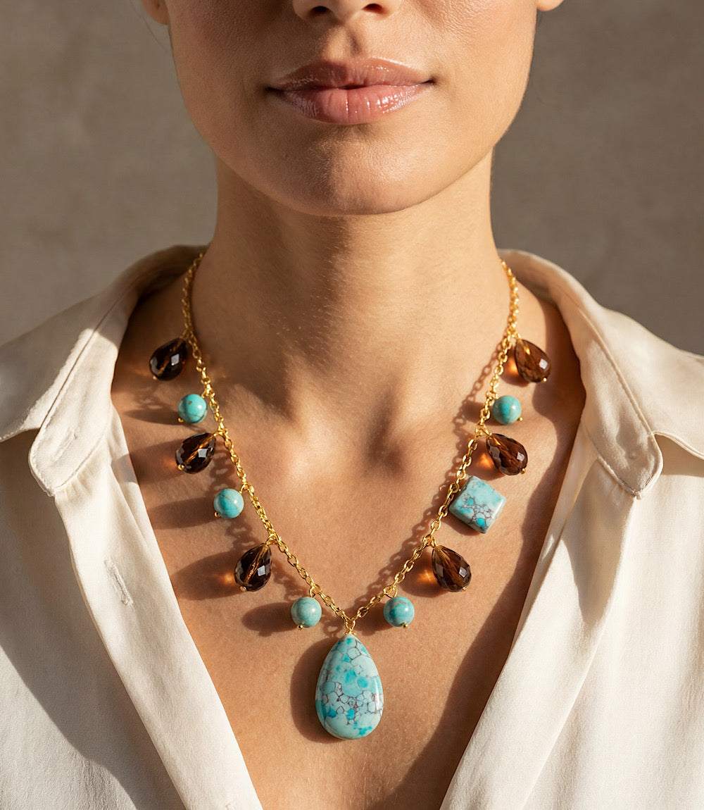 Dangling turquoise and gemstone necklace with gold-tone chain and teardrop pendant