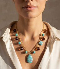 Dangling turquoise and gemstone necklace with gold-tone chain and teardrop pendant