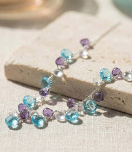 Delicate dangling gemstone necklace with blue and purple stones on silver chain