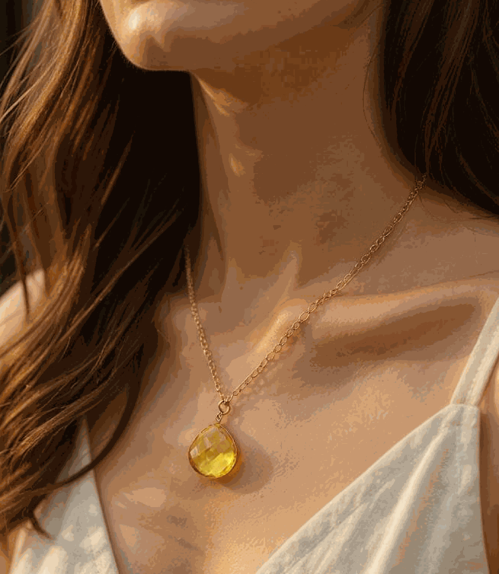 Citrine quartz pendant necklace with faceted golden stone on gold plated chain worn by woman