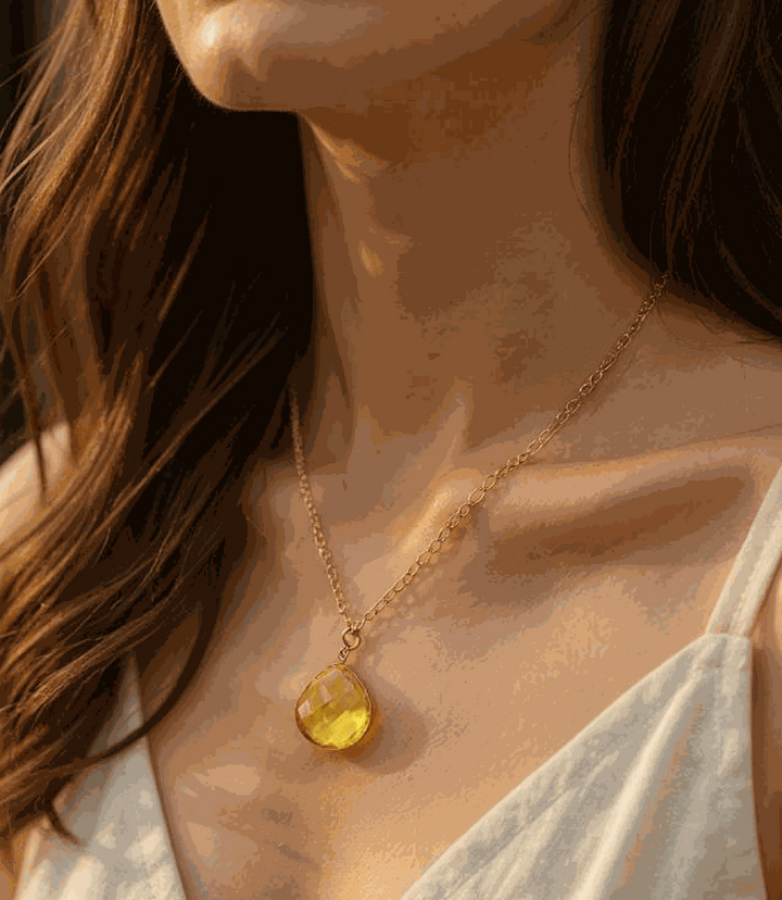 Citrine quartz pendant necklace with faceted golden stone on gold plated chain worn by woman