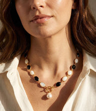 Black and white toggle necklace with gold frames, black onyx, moonstone stones, and pearl drop